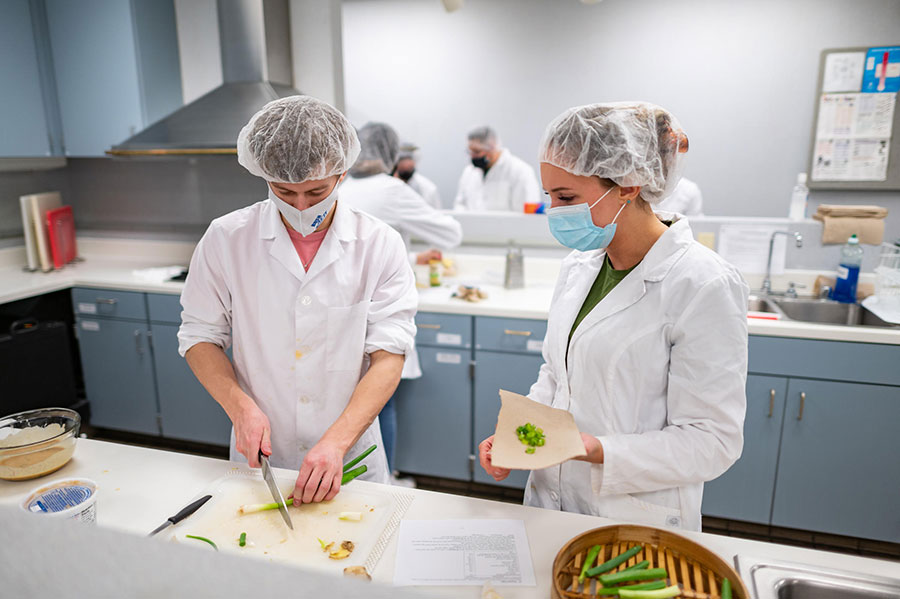 student wearing lab coats in the nutrition lab
