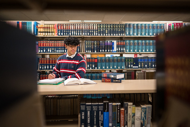 Adrian Marquina studies law books in the Meriam Library