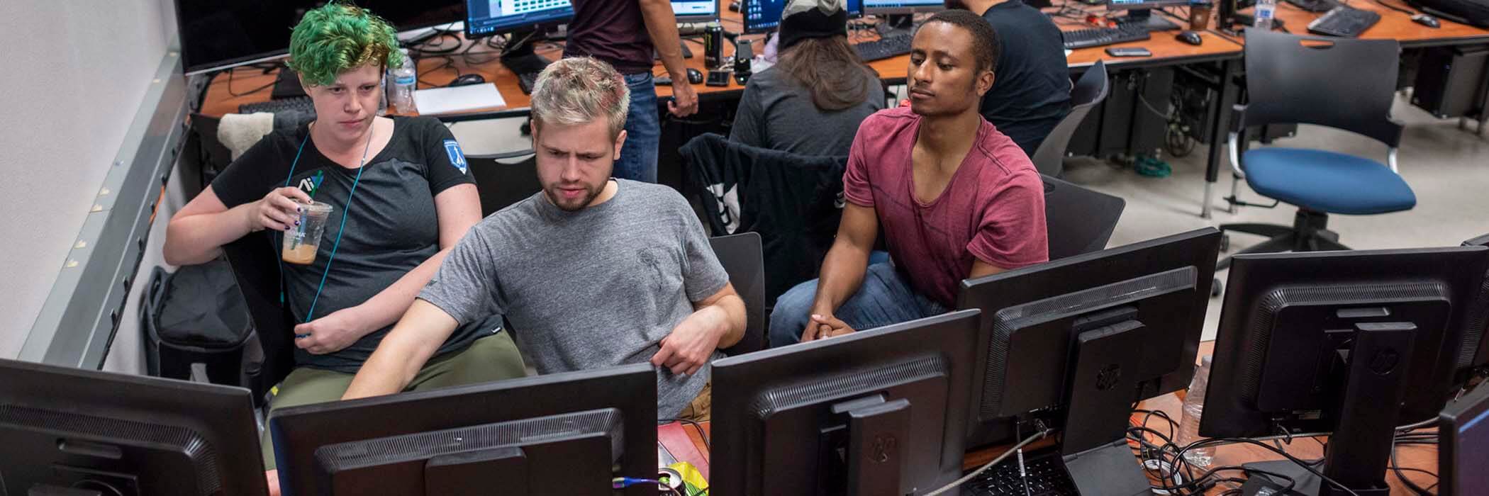 Three students looking at a computer screen
