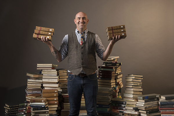 English faculty member Corey Sparks surrounded by books