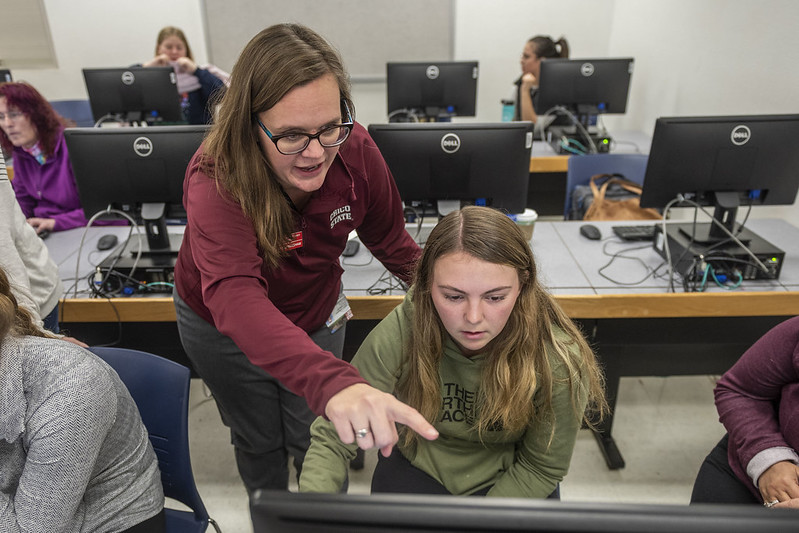 Katrina Cunningham (left) helps Kelsi Rice (right) and other displaced students from Paradise High School are helped with finalizing their college application to apply for college in a computer lab in THMA 131 