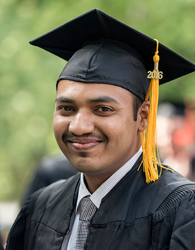 International student wearing cap and gown at graduation