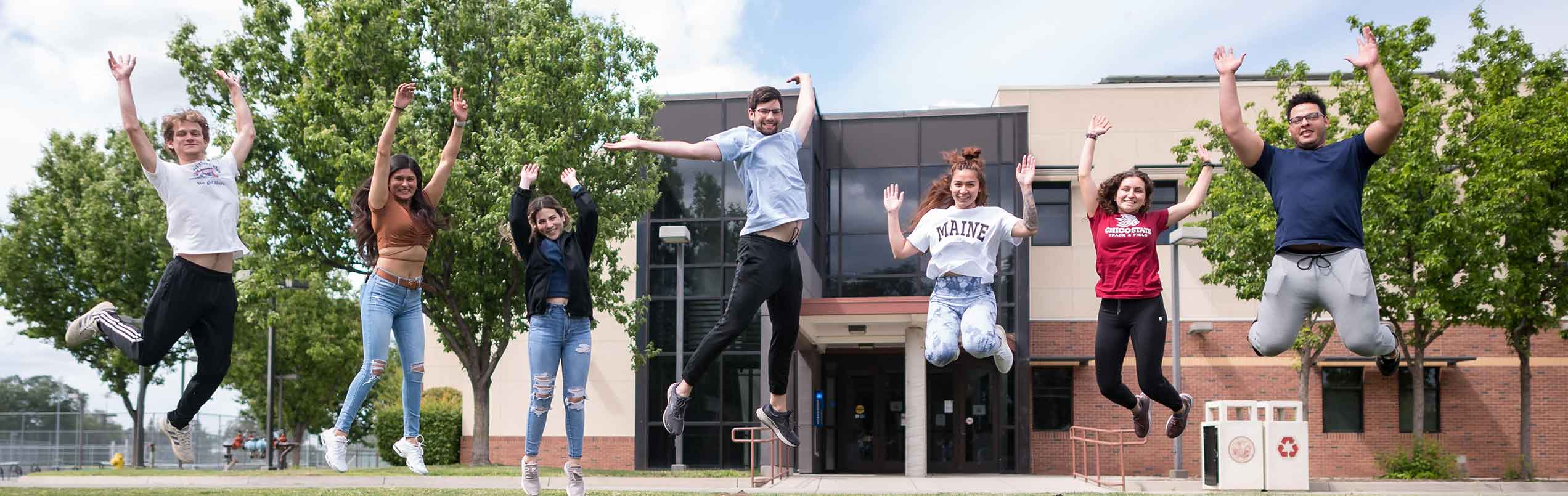 students jumping for photo on Yolo Hall lawn