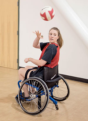 student in wheelchair throwing a ball