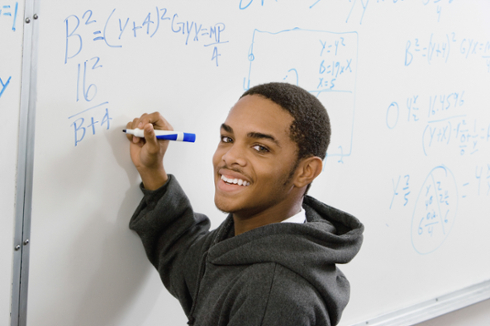 student at chalkboard doing math