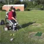 Man in adaptive seat swinging a golf club