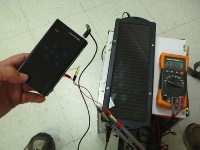 Hand holding a phone attached to generator output