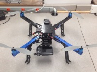 Small quad-rotor drone sitting on the ground