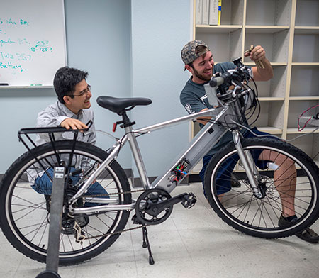 Students and Faculty working on bike