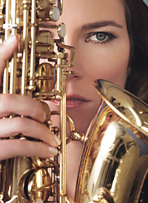 woman holding a saxophone near her face