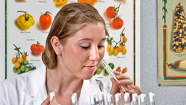 Student in food science lab with nutrition poster in the background