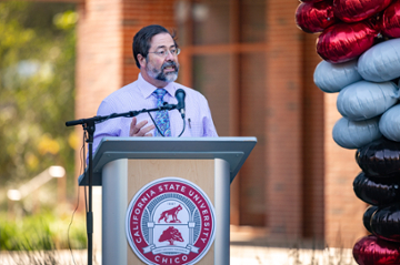 Dean David Hassenzahl stands at podium in front of new science building