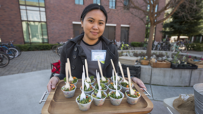 A CHC intern offers samples of a healthy salad