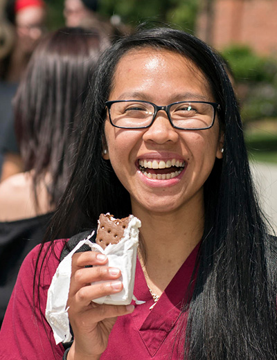 nursing student eating ice cream sandwich with big smile on face