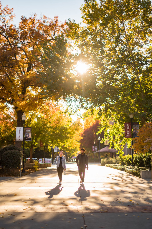 Students walk past meriam library in the autumn