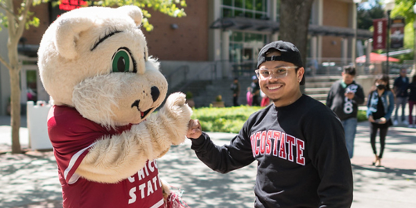 Daniel Martinez (right) takes a photo with Willie the Wildcat as prospective/adm