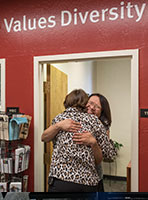 Gayle Hutchinson giving hug under the words Value Diversity