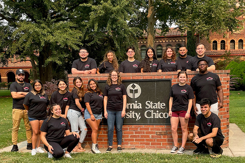 Group in front of brick Chico State sign