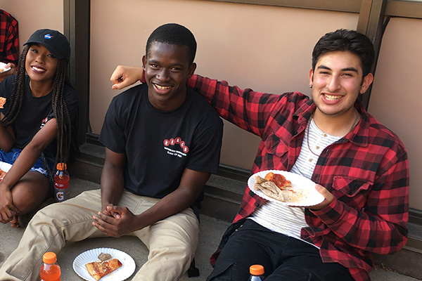 REACH student enjoying pizza with peer mentor