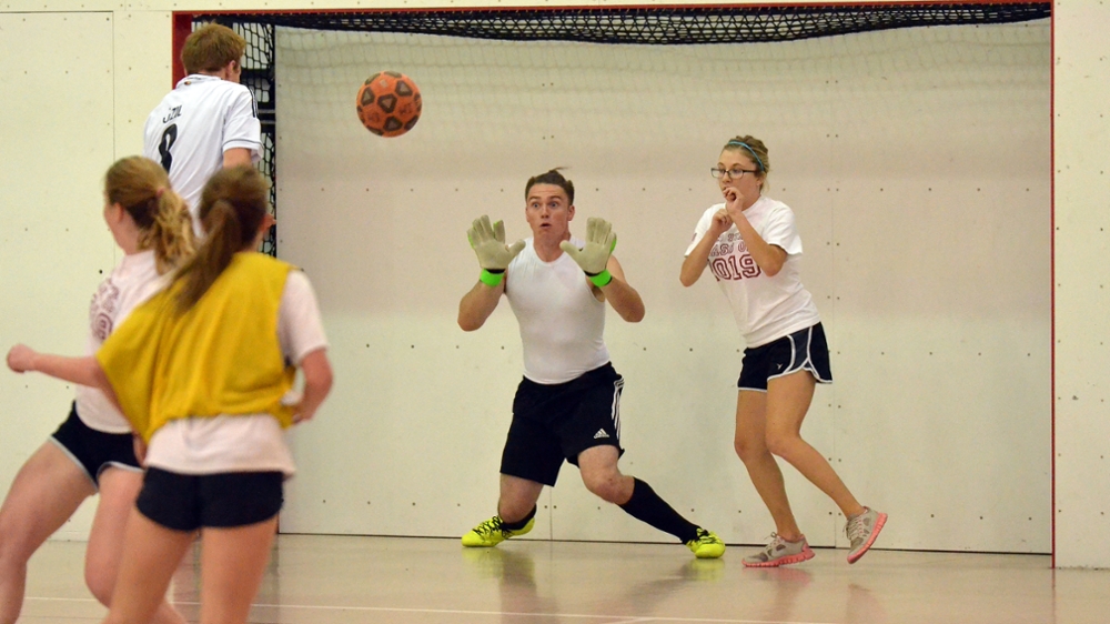 Goalie eyes on the ball as it is hit towards him in indoor soccer.