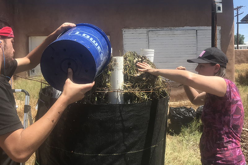 Loading the bioreactors at New Mexico State University. Pictured: Amy Larsen and Youth Farm Laborer.