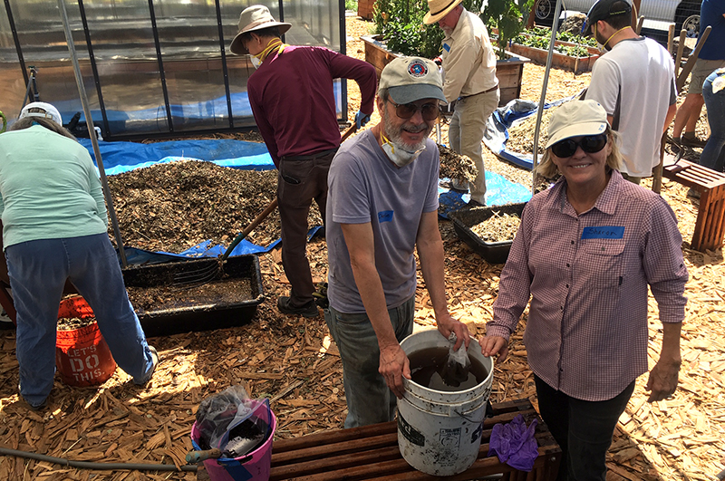 Master Gardeners preparing compost materials to fill the bioreactor.