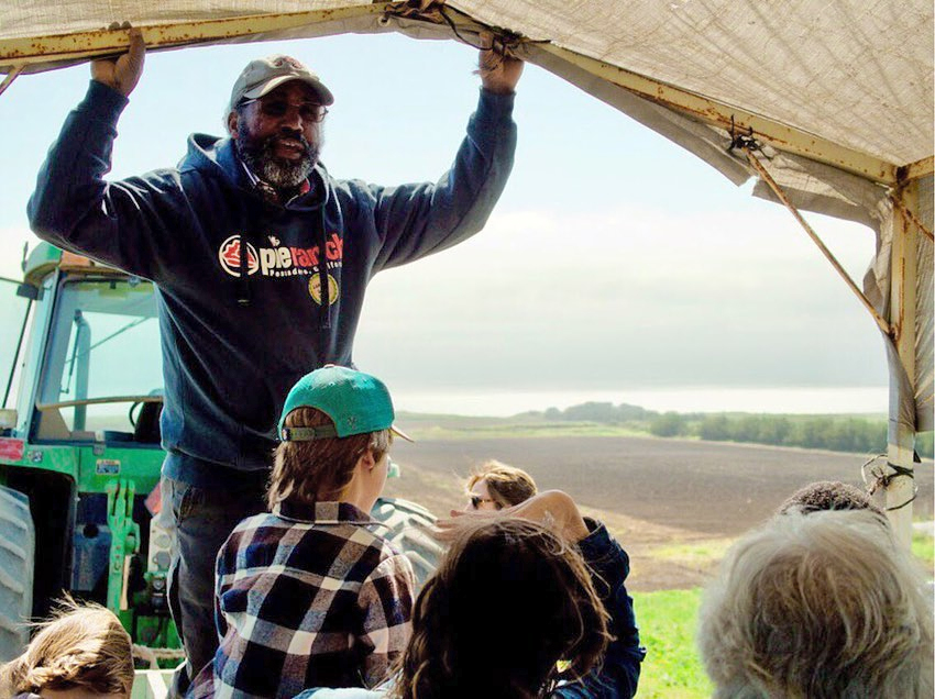 Leonard Diggs speaking to a group in a tent at Pie Ranch