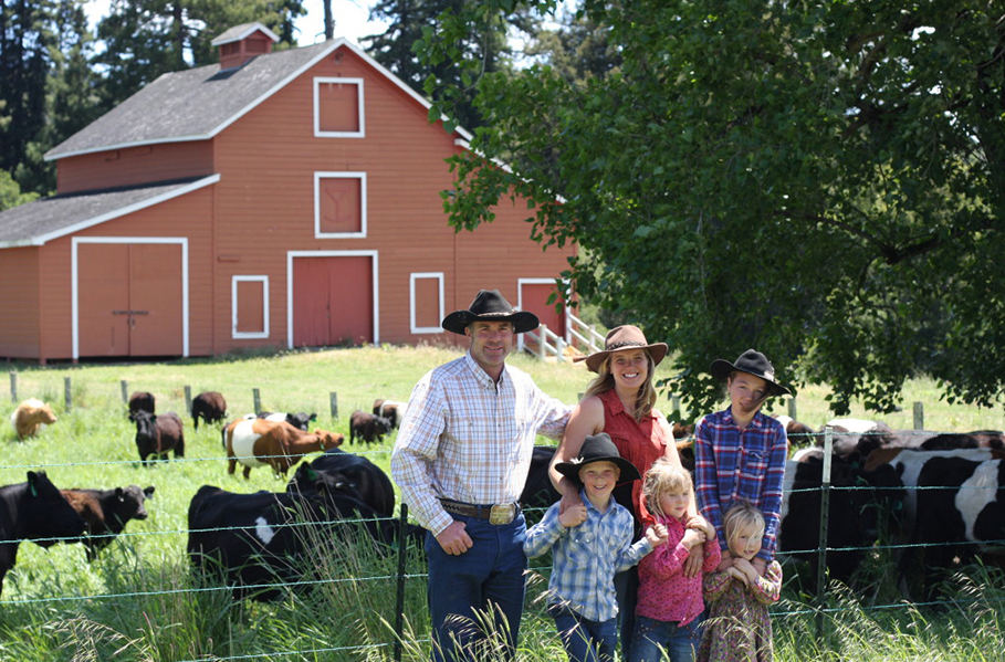 The Markegard family in front of a red barn.