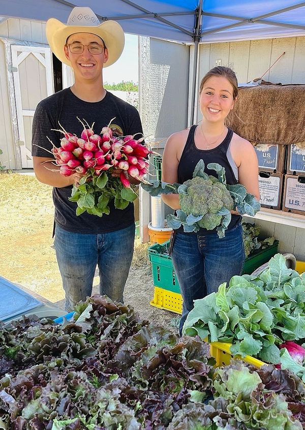 students holding vegetables at the OVP farm stand