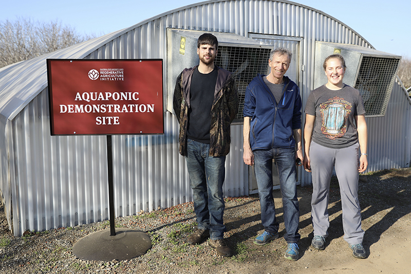 Students and faculty leader Lee Altier in front of the Aquaponics Greenhouse