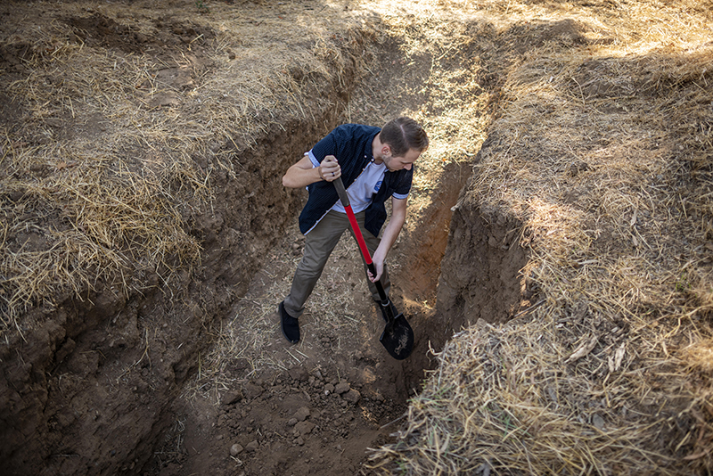 Undergraduate research assistant Seth Myrick hard at work digging at a soil sampling site.