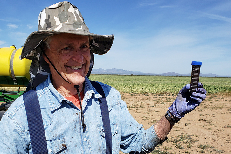 Dr. David Johnson holding BEAM compost extract in Willcox AZ