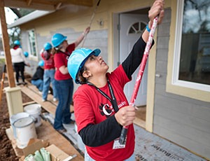 Student volunteers painting a house