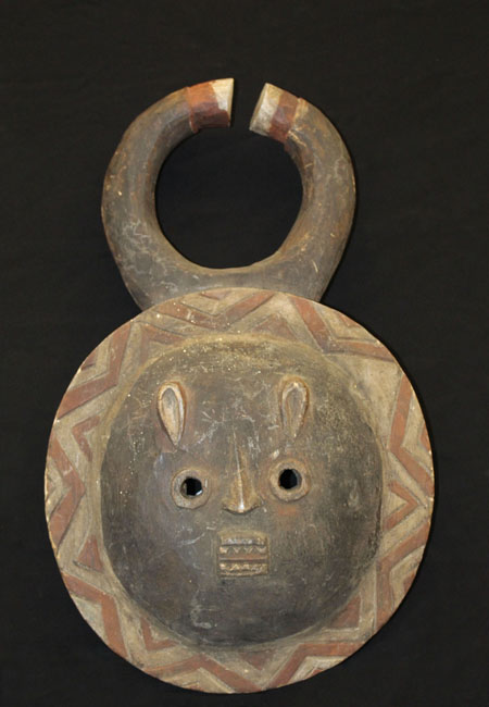 round faced mask with two curved horns and small round eyes