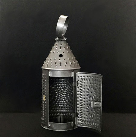 silver colored metal lantern with decorative punches into the metal