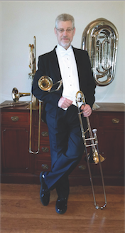 Lloyd Roby standing with brass instruments