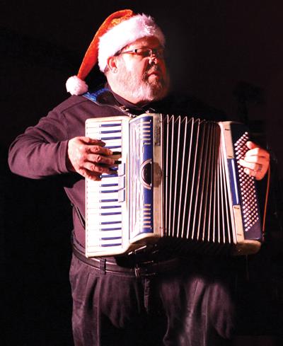 man wearing santa hat and playing accordion