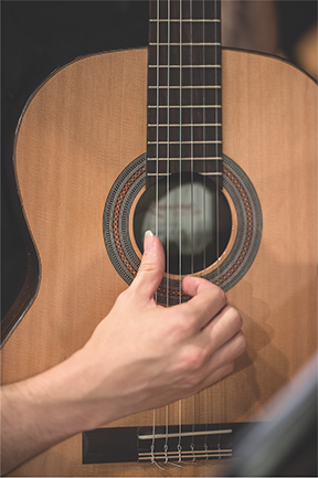 hand picking an acoustic guitar