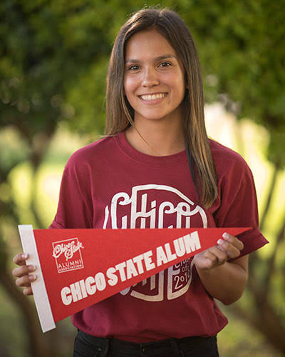 Chico State alumni holding a sign saying Chico State Alum