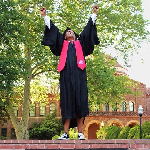 Graduate celebrating with arms in the air