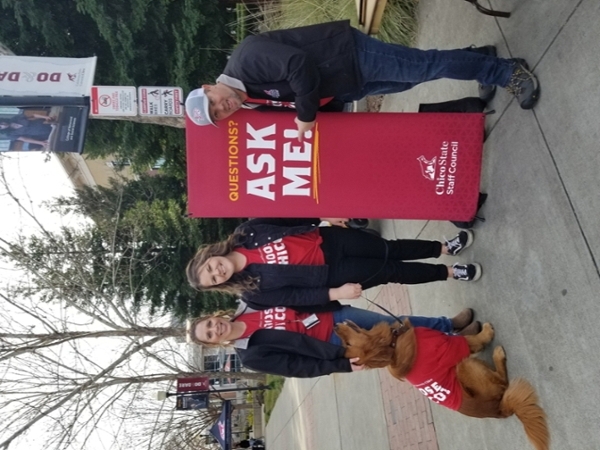 three staff and dog with ask me sign
