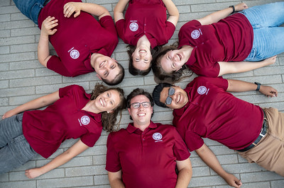 Summer Orientation leaders are posing for a picture while laying on the floor.