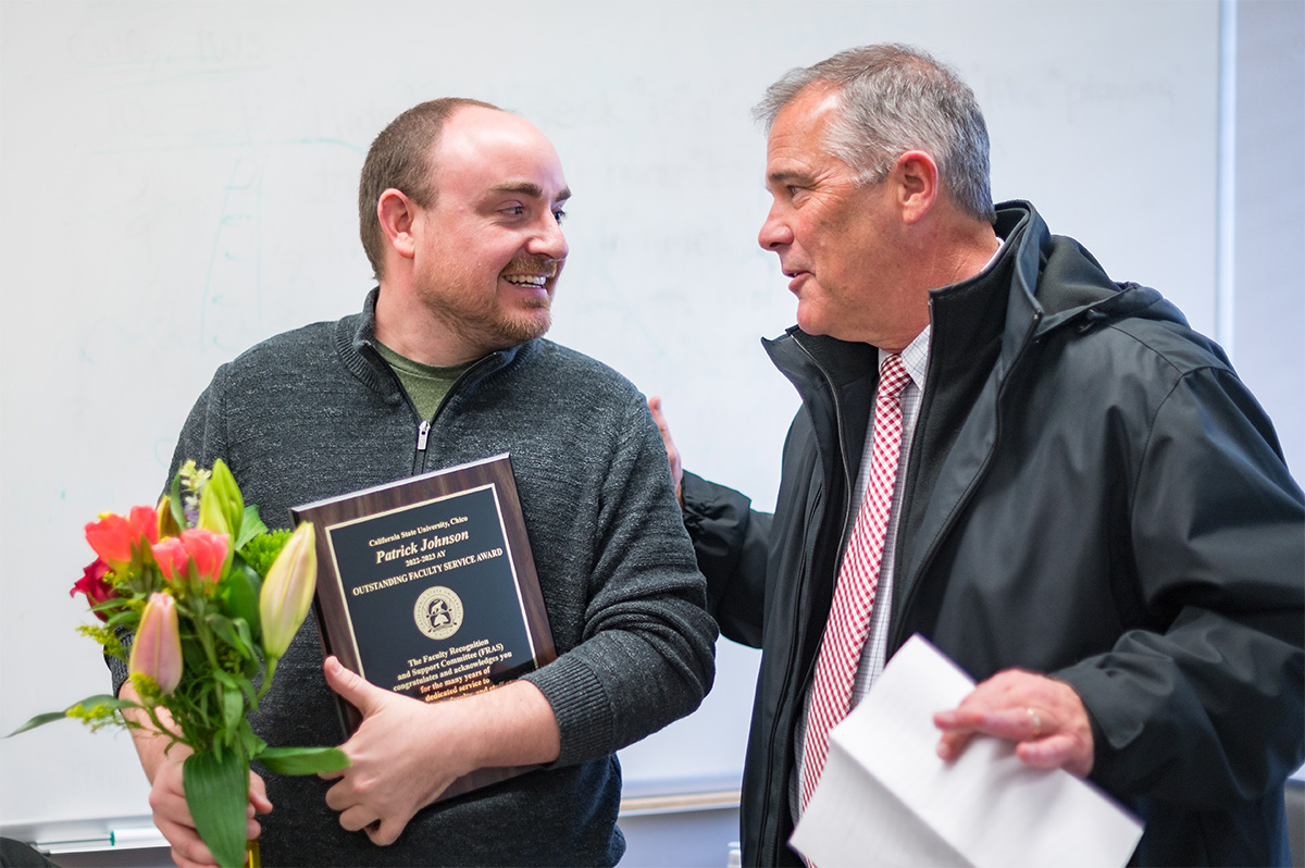 Interim Provost Steve Perez surprises Patrick Johnson with the Outstanding Faculty Service Award